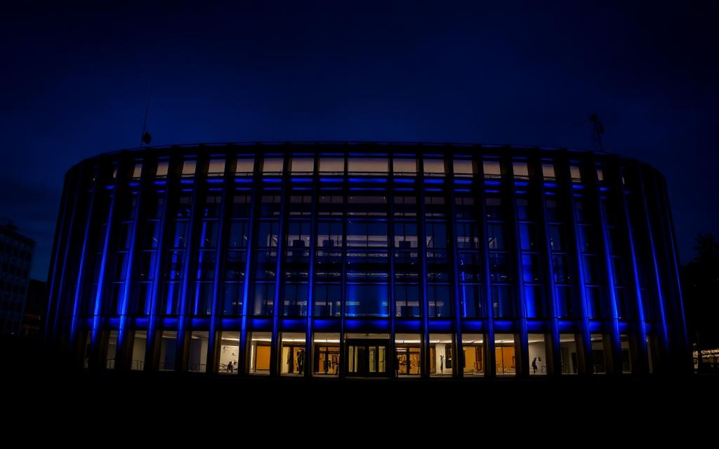 European institutional building lit blue at dusk